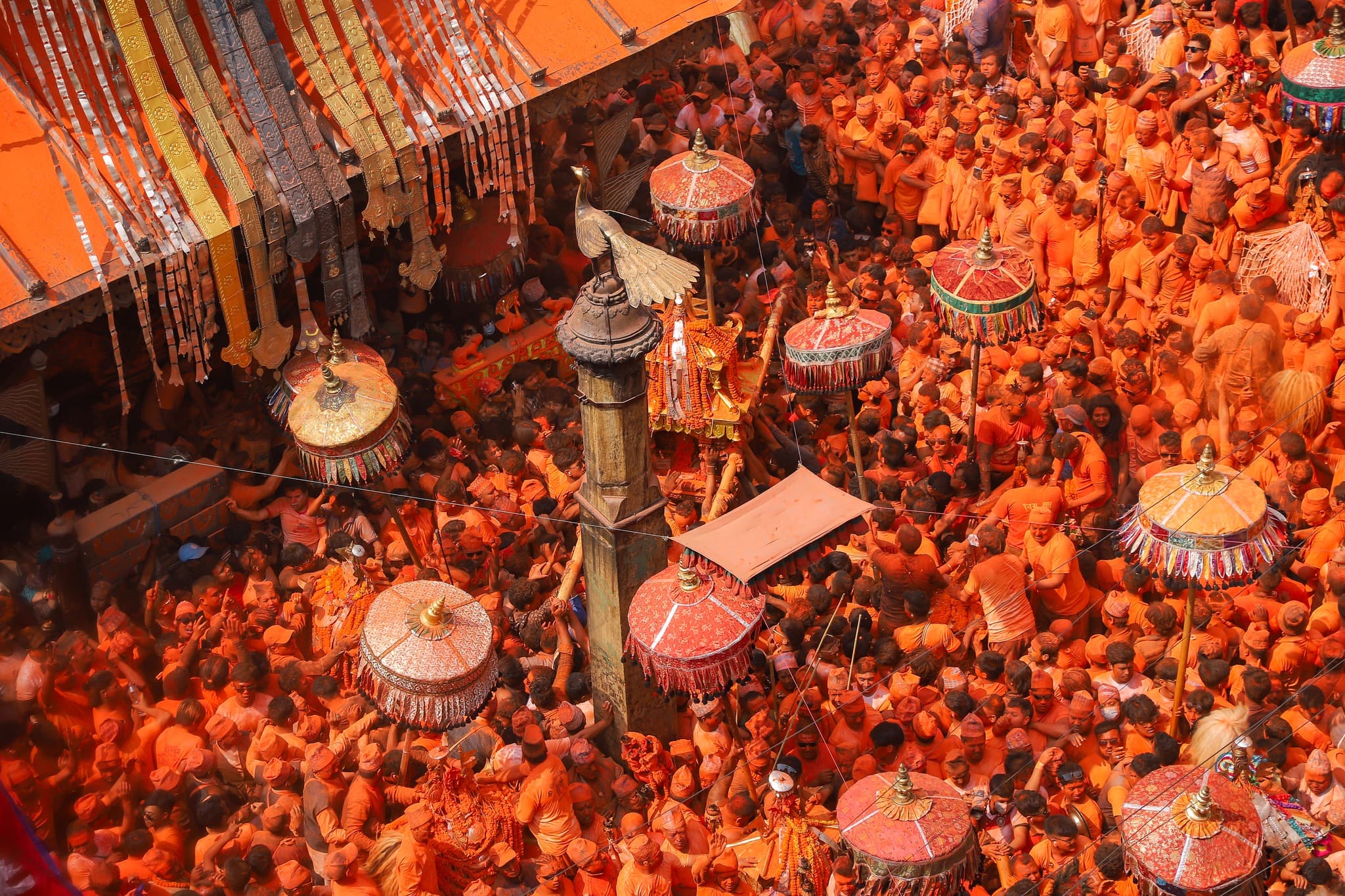 Dense festival crowd gathered around a ceremonial space in Thimi.